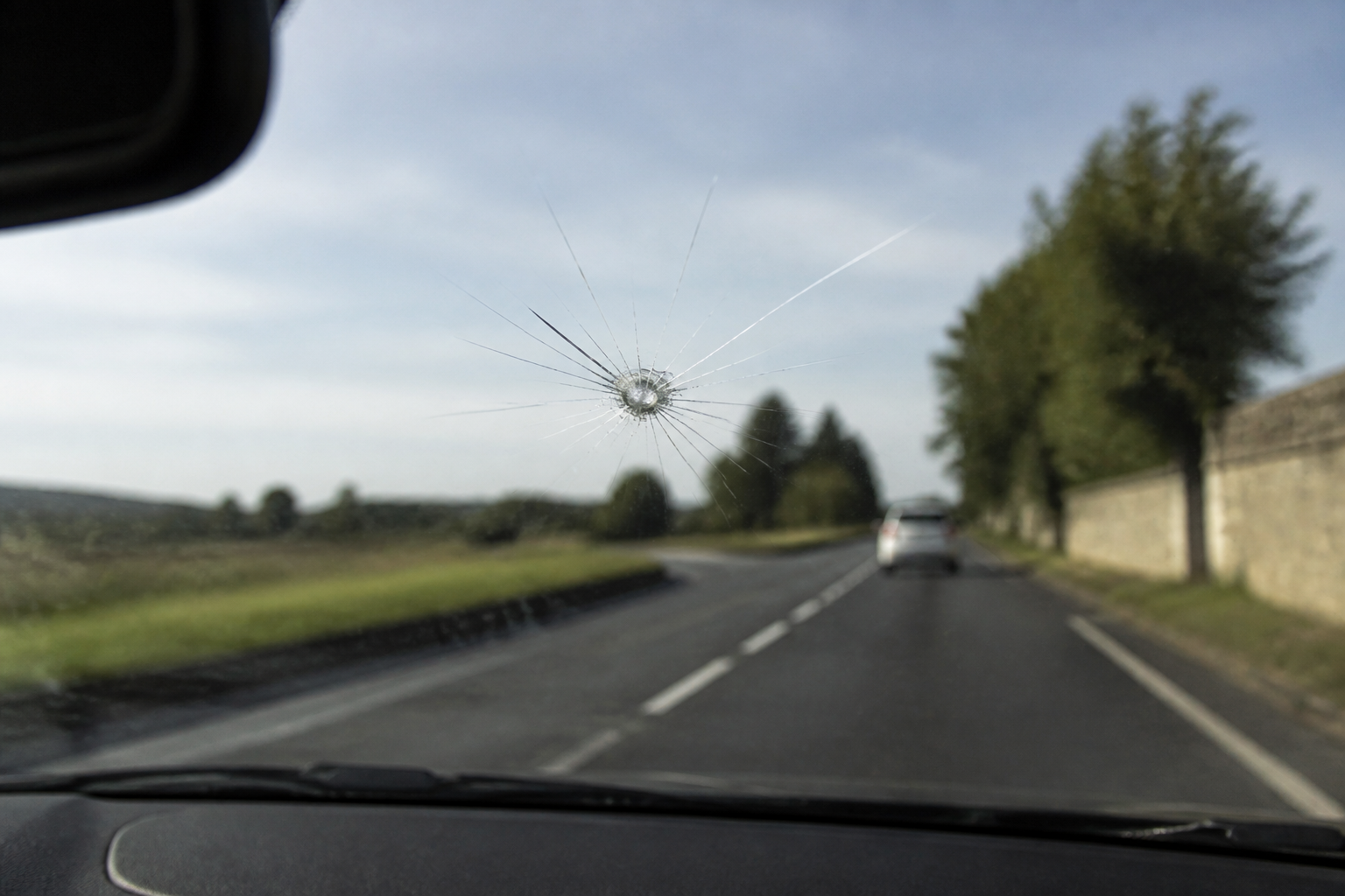Impact visible sur le pare-brise dans la zone de visibilité du conducteur
