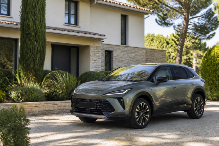 Voiture hybride moderne garée devant une maison